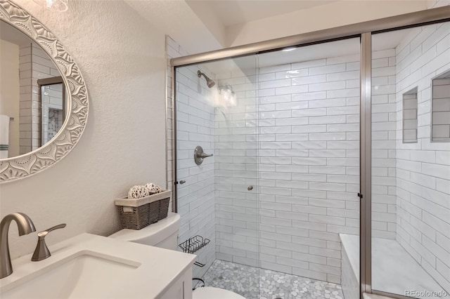 8985 Lander St, Westminster, CO 80031 - bathroom featuring toilet, a stall shower, vanity, and a textured wall