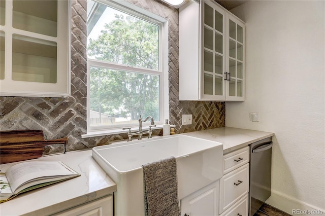 4818 Bryant St, Denver, CO 80221 - kitchen featuring backsplash, dishwasher, white cabinetry, light stone countertops, and glass insert cabinets