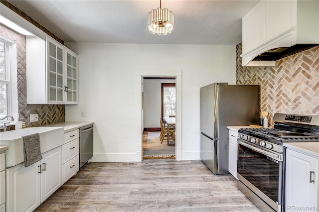 4818 Bryant St, Denver, CO 80221 - kitchen featuring appliances with stainless steel finishes, tasteful backsplash, light countertops, and glass insert cabinets