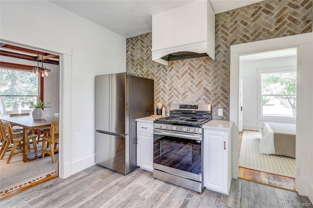 4818 Bryant St, Denver, CO 80221 - kitchen featuring appliances with stainless steel finishes, light countertops, white cabinetry, and light wood-type flooring