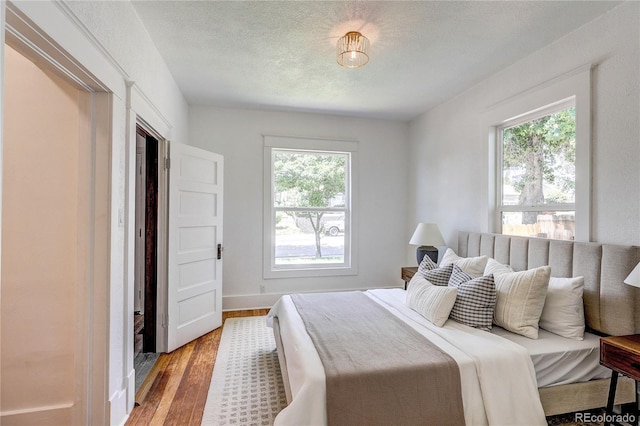 4818 Bryant St, Denver, CO 80221 - bedroom featuring multiple windows, wood finished floors, and a textured ceiling