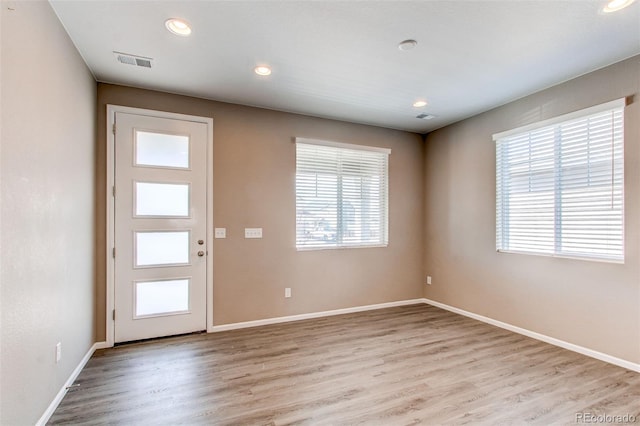 entrance foyer with light wood-style flooring, visible vents, a wealth of natural light, and baseboards
