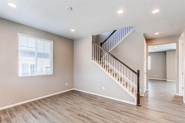 spare room with wood finished floors, baseboards, and recessed lighting
