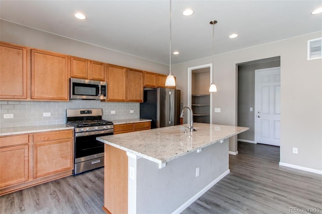 kitchen with light wood-style flooring, a sink, baseboards, and stainless steel appliances