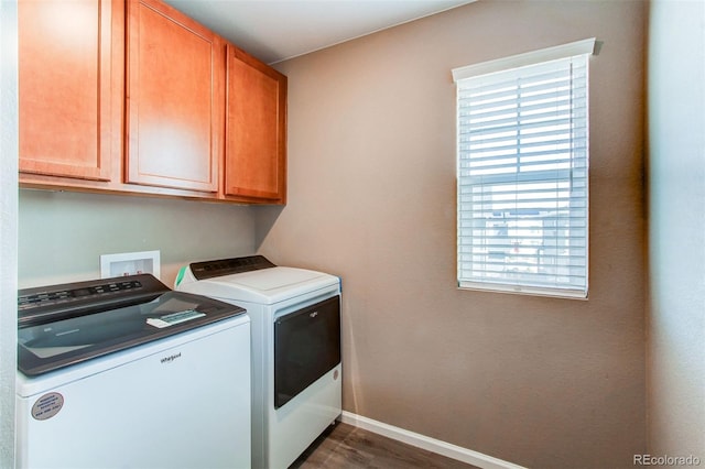 laundry area with dark wood-style floors, baseboards, cabinet space, and washing machine and dryer