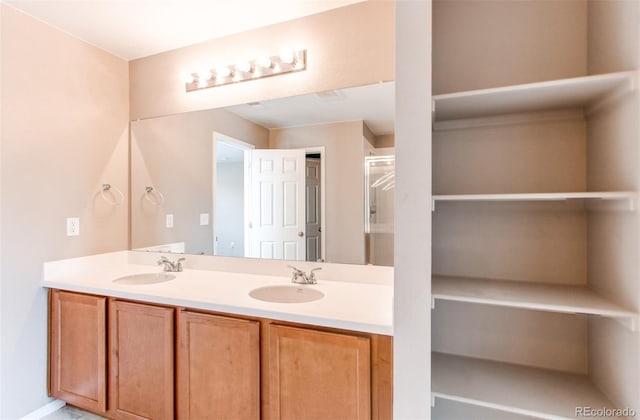 bathroom with a sink, double vanity, and a stall shower