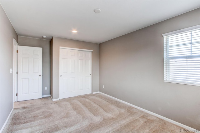 unfurnished bedroom featuring a closet, baseboards, and carpet floors