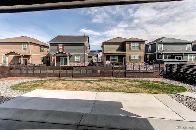 exterior space with a fenced front yard and a residential view