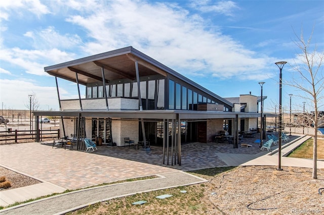 back of house with fence, a patio, and a sunroom