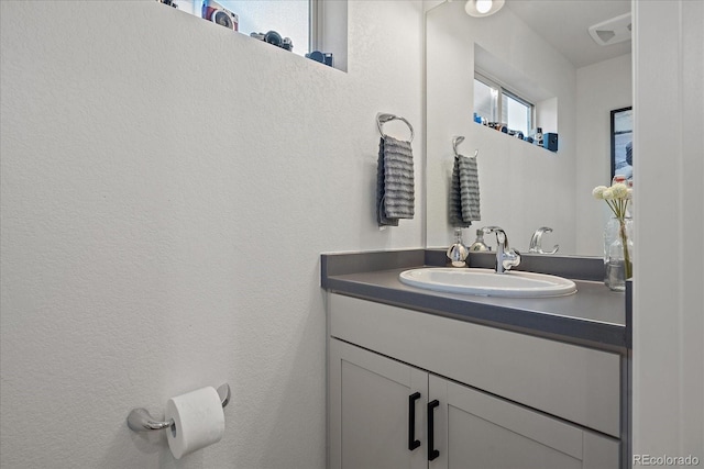 bathroom featuring a textured wall and vanity