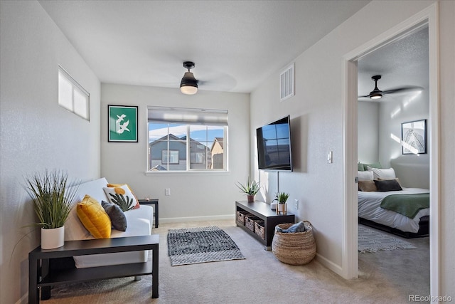 sitting room with carpet floors, baseboards, and visible vents