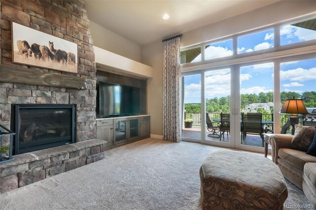 17275 Gwilym Ct, Monument, CO 80132 - living room featuring carpet floors, a fireplace, a high ceiling, and baseboards