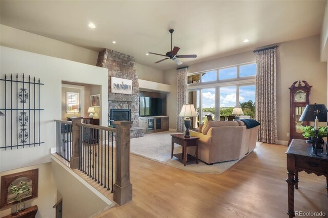 17275 Gwilym Ct, Monument, CO 80132 - living area featuring a ceiling fan, light wood-style floors, recessed lighting, and a stone fireplace