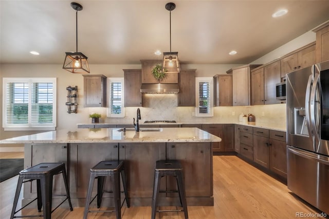 17275 Gwilym Ct, Monument, CO 80132 - kitchen featuring appliances with stainless steel finishes, a sink, plenty of natural light, light stone countertops, and recessed lighting