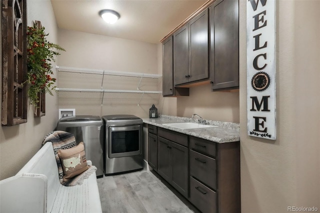 17275 Gwilym Ct, Monument, CO 80132 - washroom featuring washer and clothes dryer, light wood-style floors, and cabinet space