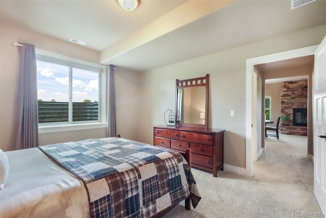 17275 Gwilym Ct, Monument, CO 80132 - bedroom featuring light colored carpet, multiple windows, baseboards, and a stone fireplace