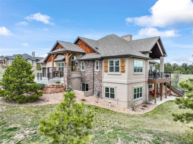 17275 Gwilym Ct, Monument, CO 80132 - rear view of property featuring stairway, a shingled roof, stucco siding, a lawn, and a deck