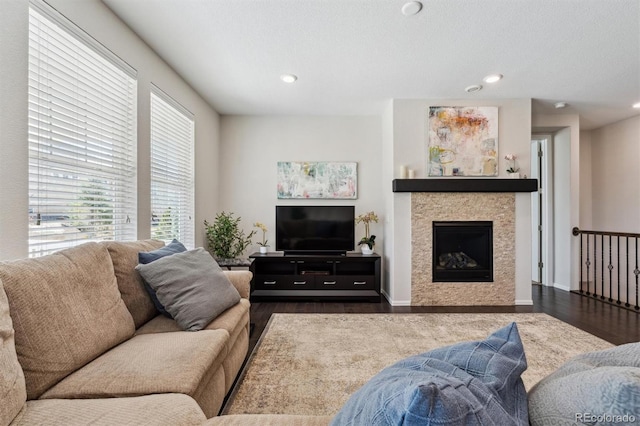 living room featuring a fireplace, dark wood-type flooring, and recessed lighting