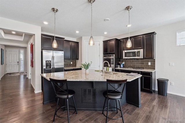 kitchen featuring stainless steel appliances, dark wood-type flooring, and a kitchen breakfast bar