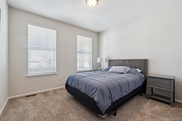 carpeted bedroom with visible vents and baseboards