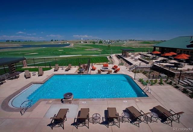 community pool with an outdoor fire pit, a patio area, and fence