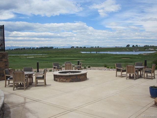 view of patio / terrace with outdoor dining space, a water view, and a fire pit