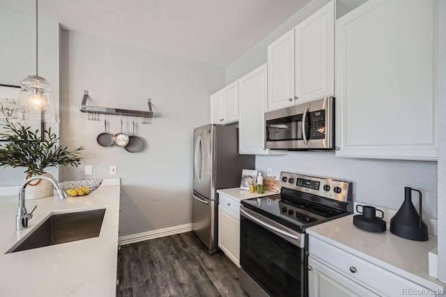 kitchen with sink, white cabinetry, hanging light fixtures, appliances with stainless steel finishes, and dark hardwood / wood-style floors