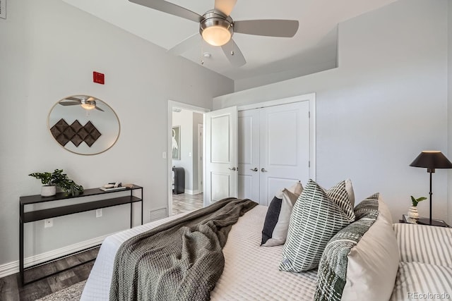 bedroom with ceiling fan, wood-type flooring, vaulted ceiling, and a closet