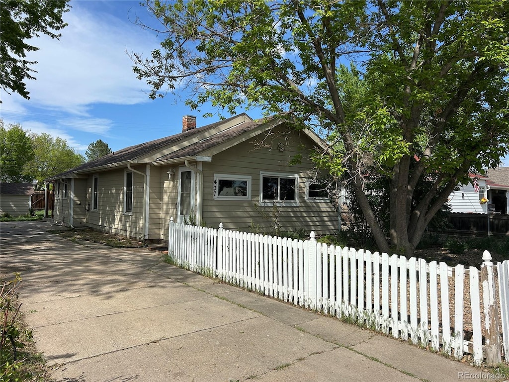 437 6th St, Frederick, CO 80530 - view of property exterior featuring a chimney and fence