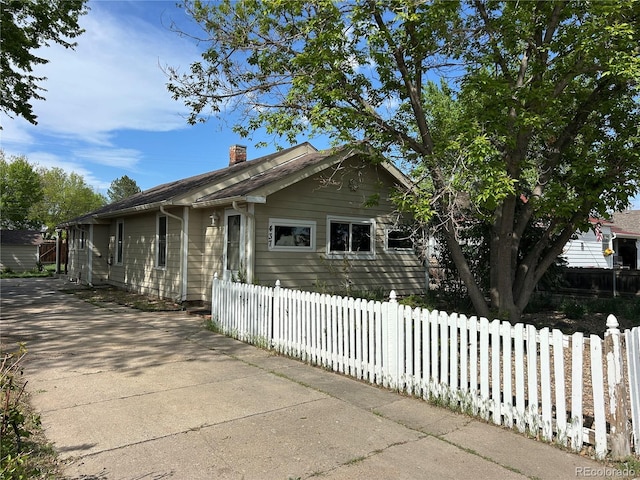 437 6th St, Frederick, CO 80530 - view of property exterior featuring a chimney and fence