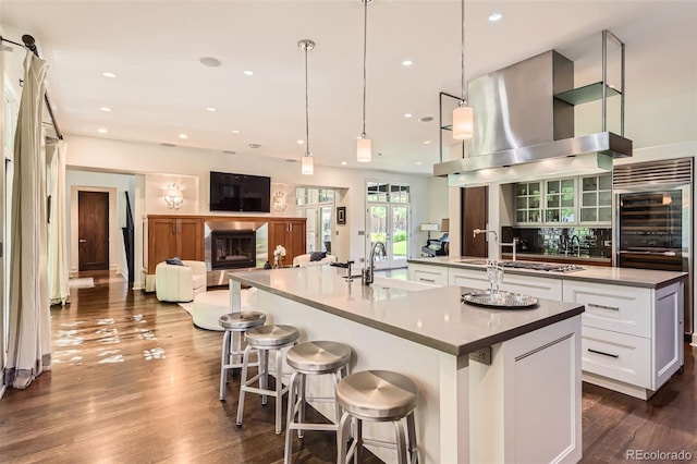 235 Eudora St, Denver, CO 80220 - kitchen featuring a spacious island, exhaust hood, white cabinets, dark wood-type flooring, and recessed lighting