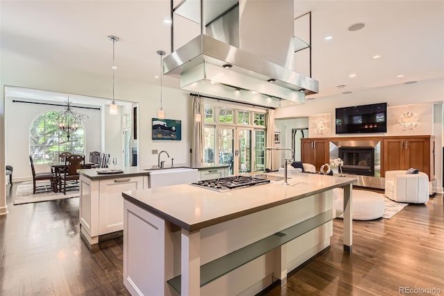 235 Eudora St, Denver, CO 80220 - kitchen with wall chimney exhaust hood, a large island with sink, healthy amount of natural light, stainless steel gas stovetop, and recessed lighting