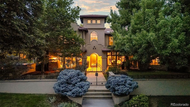 235 Eudora St, Denver, CO 80220 - mediterranean / spanish-style house with stucco siding, a fenced front yard, and a tiled roof