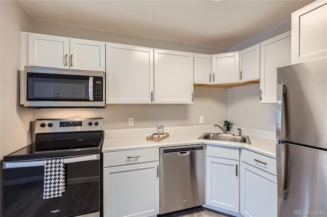 kitchen featuring appliances with stainless steel finishes, sink, and white cabinets