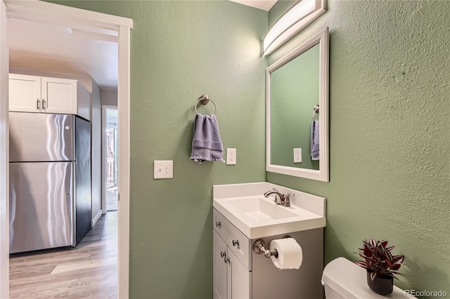 bathroom featuring hardwood / wood-style flooring, vanity, and toilet