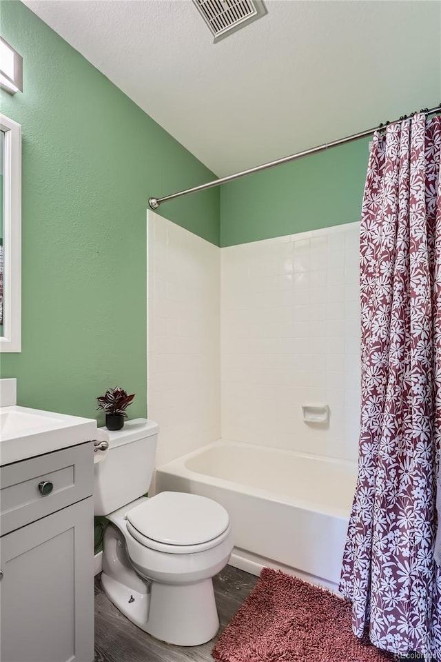 full bathroom with vanity, hardwood / wood-style floors, shower / bath combination with curtain, and toilet