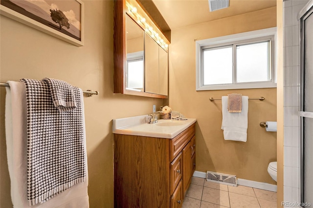 bathroom featuring toilet, baseboards, visible vents, and tile patterned flooring