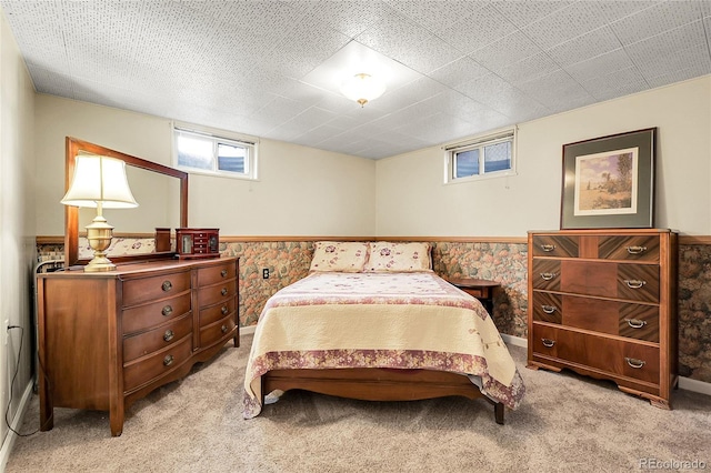 bedroom featuring light carpet and wainscoting