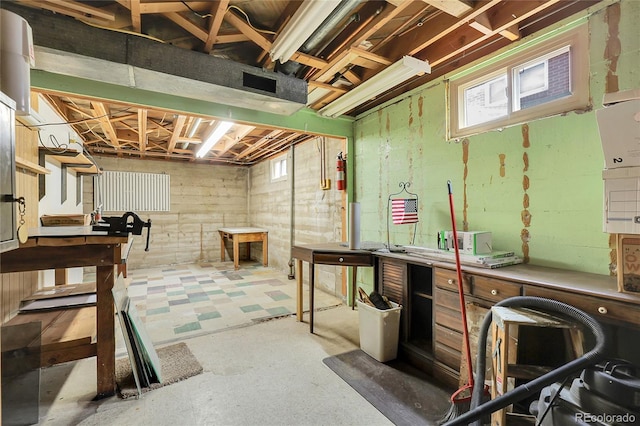 below grade area with tile patterned floors, a workshop area, and a wealth of natural light