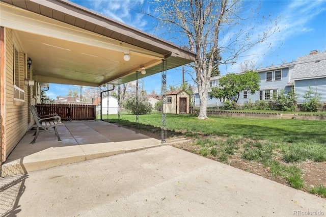 view of patio / terrace featuring an outdoor structure, fence, and a storage unit