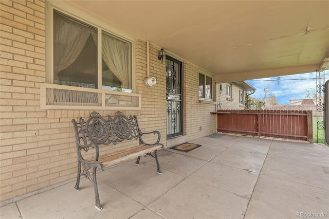 view of patio featuring fence and covered porch