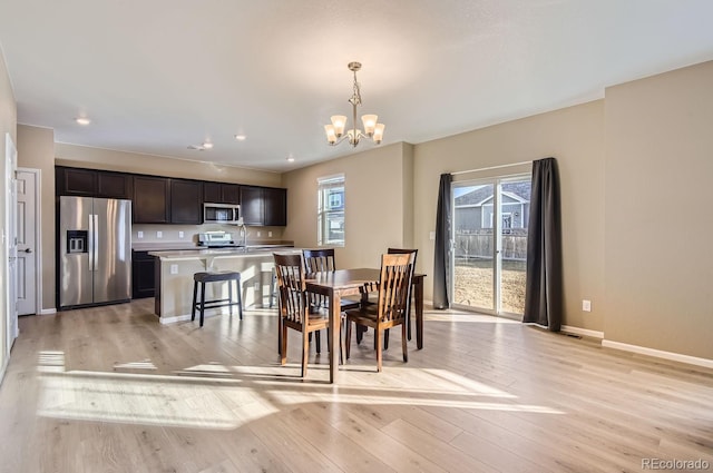 dining area with a notable chandelier and light wood-type flooring