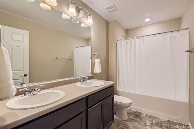 full bathroom with vanity, shower / bath combo, and toilet