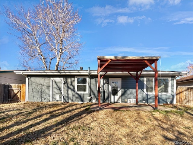 back of house with a lawn and a patio