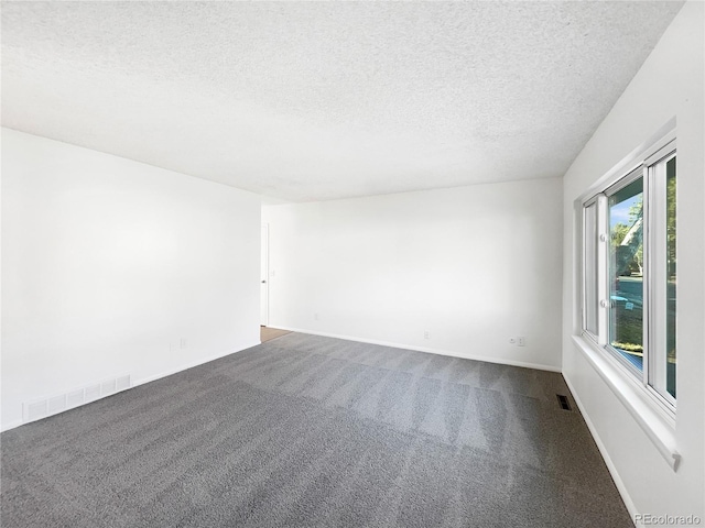 carpeted spare room featuring a textured ceiling