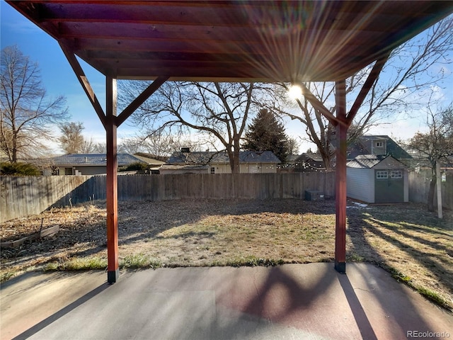 view of yard featuring a storage unit and a patio area