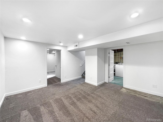 basement featuring dark carpet and washer / dryer