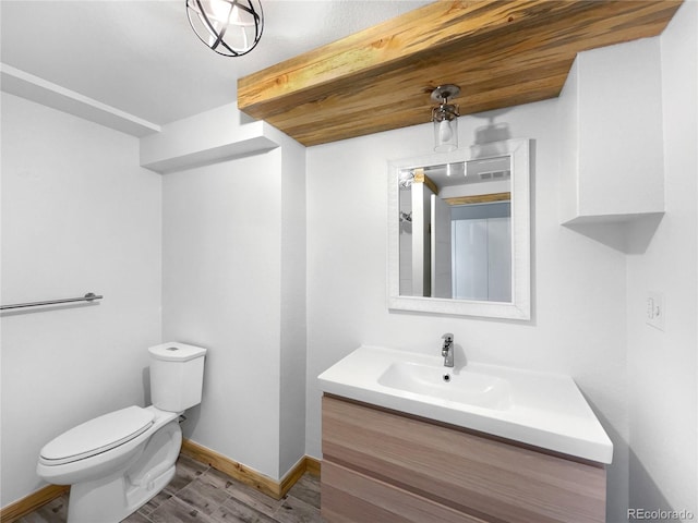 bathroom with toilet, vanity, and hardwood / wood-style flooring