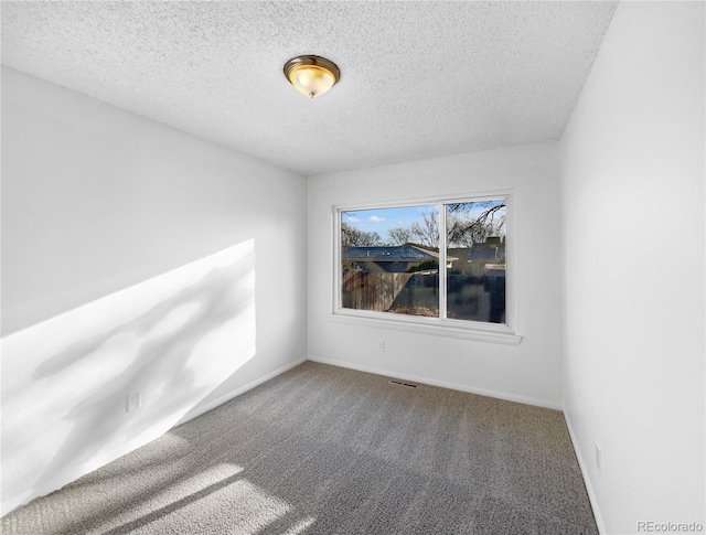 carpeted spare room with a textured ceiling