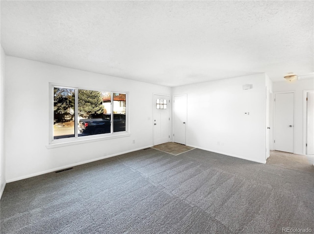 unfurnished room featuring a textured ceiling and carpet floors